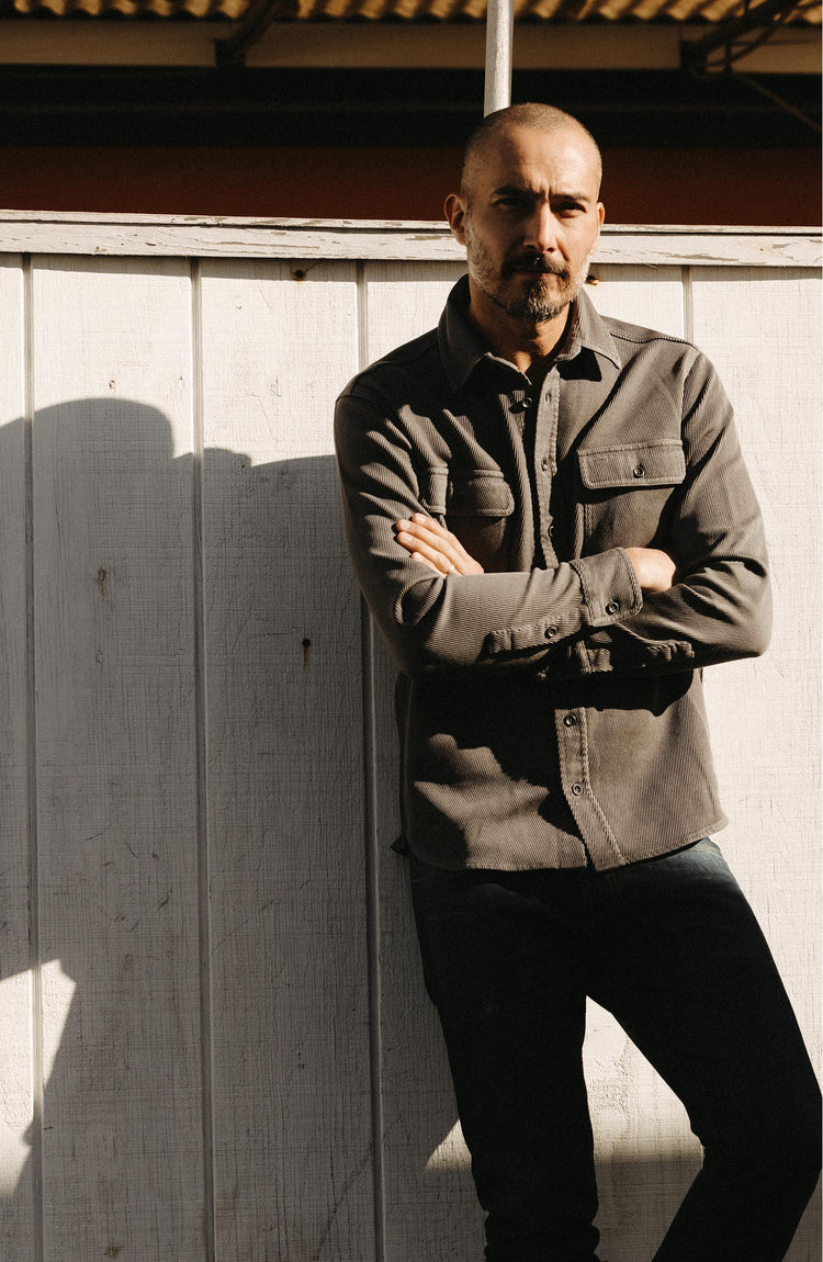 fit model leaning against the wall wearing The Ledge Shirt in Shale Twill
