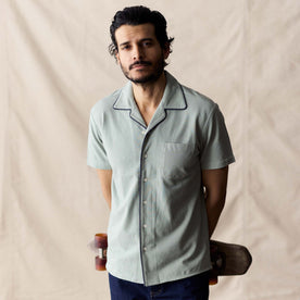 fit model holding a skateboard wearing The Harwich Shirt in Surf Green Tipped Pique