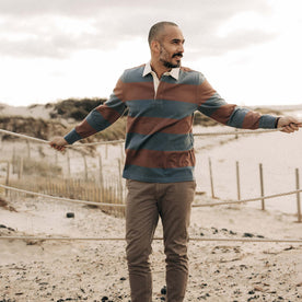 fit model leaning against a rope wearing The Rugby Shirt in Faded Brick Stripe