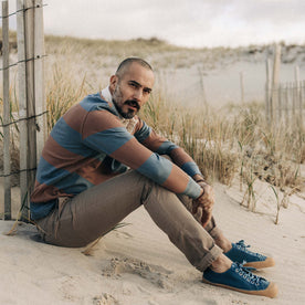 fit model sitting on the beach in The Rugby Shirt in Faded Brick Stripe