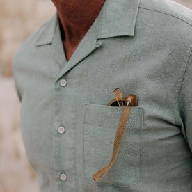 fit model showing off the button on The Short Sleeve Hawthorne in Sea Moss Floral