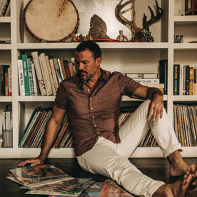fit model wearing The Short Sleeve Hawthorne in Burgundy Trellis, sitting down with vinyl