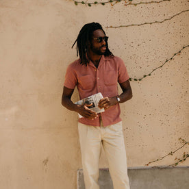 fit model leaning against the wall wearing The Conrad Shirt in Fired Brick Dobby
