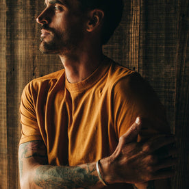 Fit Model rubbing arm while wearing tee shirt