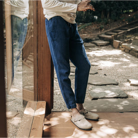 fit model leaning against the wall wearing The Apres Pant in Indigo Waffle